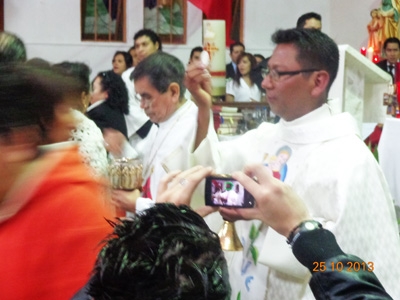 GermÃ n next to the Bishop distributing communion.jpg